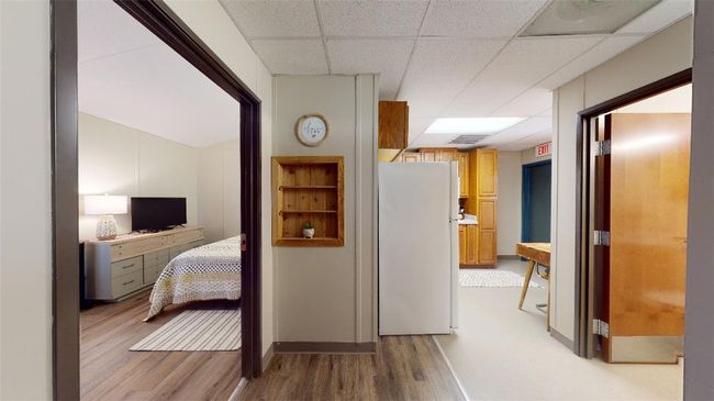 Hallway featuring a paneled ceiling and light wood-style floors | Image 14