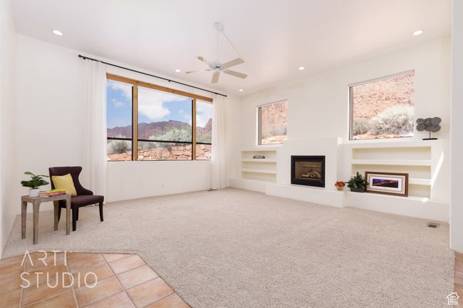 Unfurnished living room featuring ceiling fan, carpet floors, a glass covered fireplace, built in features, and recessed lighting | Image 13