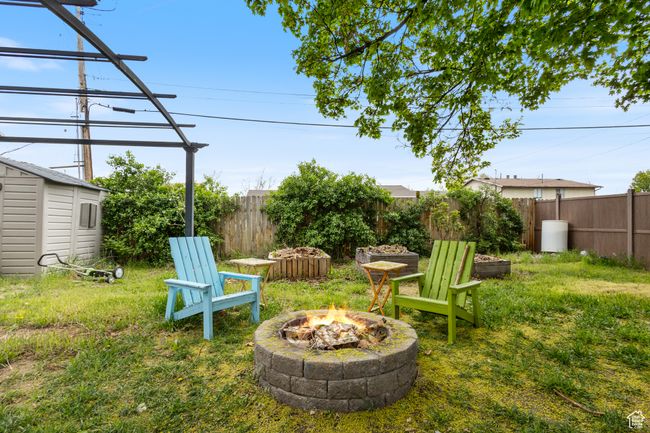 View of yard with a fire pit, a storage unit, an outbuilding, and a fenced backyard | Image 18