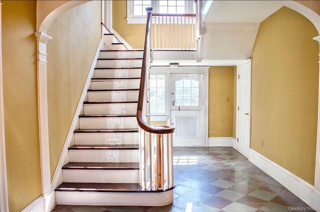 Entrance foyer featuring arched walkways, healthy amount of natural light, stairway, and a high ceiling | Image 8