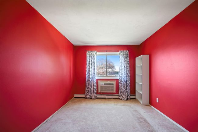 Spare room with baseboards, a baseboard heating unit, carpet, and a wall mounted air conditioner | Image 13
