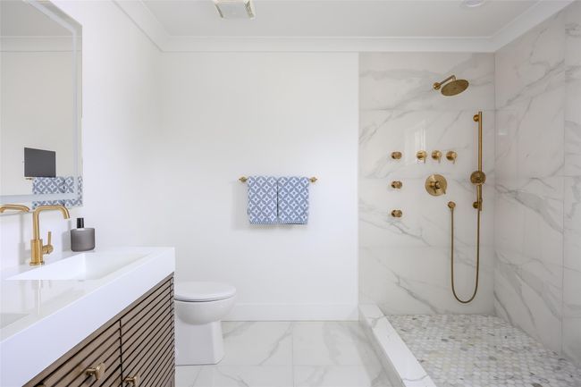 Full bath featuring marble finish floors, a marble finish shower, vanity, and crown molding | Image 33