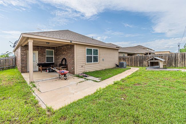 Rear view of property featuring brick siding, a patio, roof with shingles, and central AC unit | Image 31