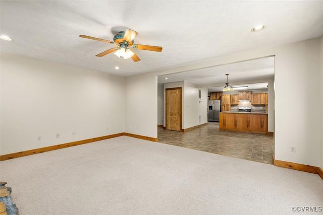 Unfurnished living room featuring dark carpet and ceiling fan | Image 32