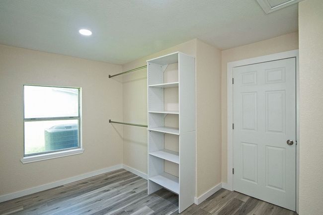 Primary closet with wood finished floors | Image 17