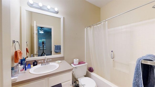 Bathroom with shower / bath combo with shower curtain, ceiling fan, toilet, and vanity | Image 13