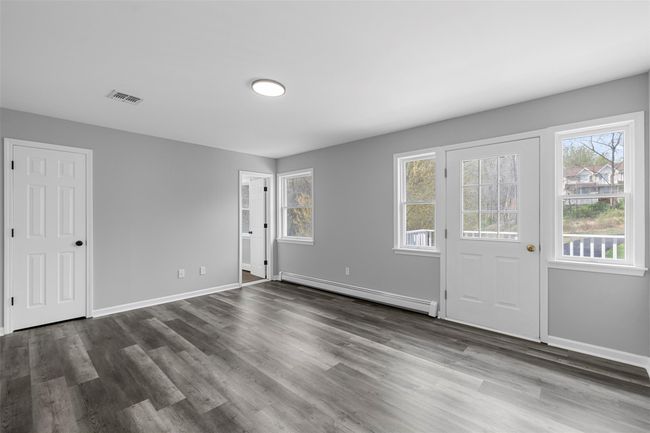 Foyer entrance featuring dark wood finished floors, visible vents, a wealth of natural light, and a baseboard radiator | Image 20