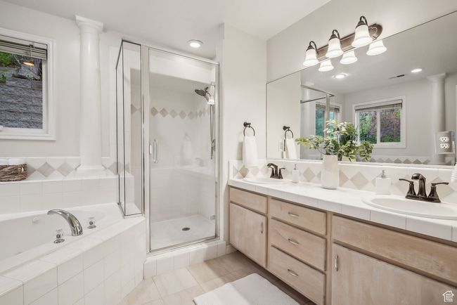 Primary bathroom with a shower stall, double vanity, a bath, and a sink | Image 16