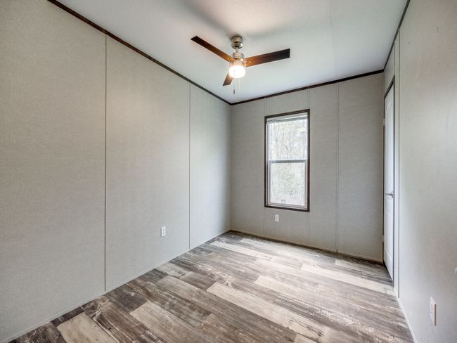 Unfurnished bedroom featuring ornamental molding, wood finished floors, and a ceiling fan | Image 12