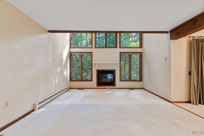 Family features a gas fireplace and wall of windows with a picturesque view! | Image 7