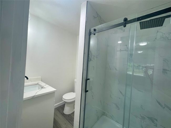 Bathroom with vanity, a marble finish shower, and wood finished floors | Image 15