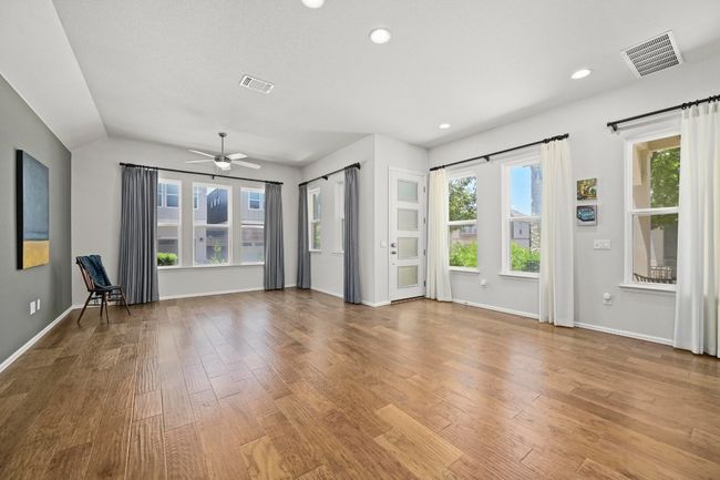 Unfurnished living room featuring wood finished floors, a ceiling fan, recessed lighting, and lofted ceiling | Image 10