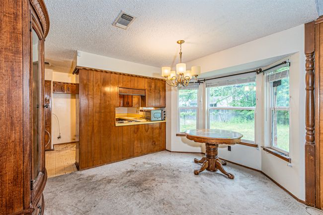 Dining room featuring an inviting chandelier, visible vents, a healthy amount of sunlight, and light carpet | Image 23