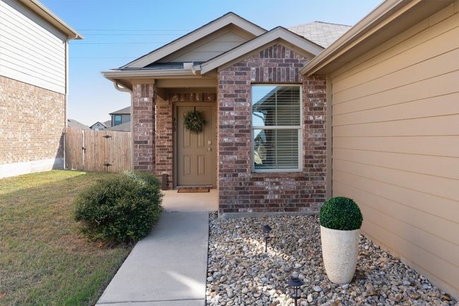 A charming brick facade and lovely landscaping greet you at the entry. | Image 8