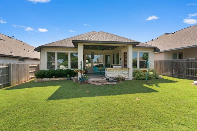 Rear view of property featuring a ceiling fan, a patio, a shingled roof, and stucco siding | Image 33