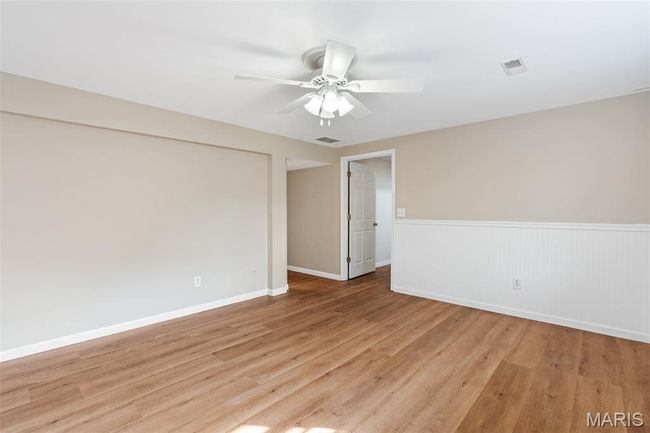 Spare room featuring a ceiling fan, light wood-style floors, wainscoting, and baseboards | Image 25