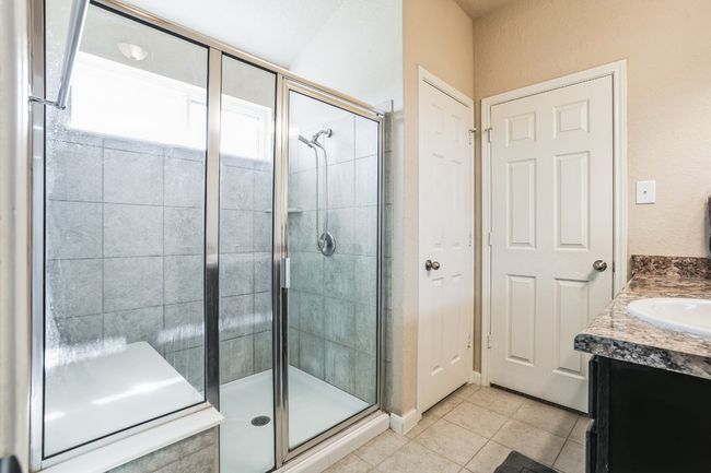 Bathroom with vanity, an enclosed shower, and tile patterned floors | Image 12