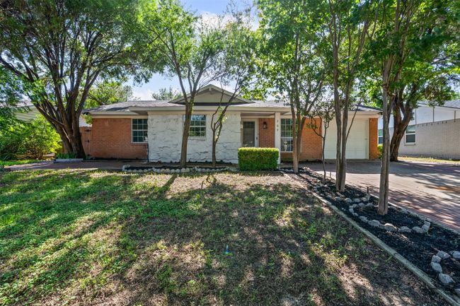Ranch-style house with an attached garage, driveway, brick siding, and stone siding | Image 4