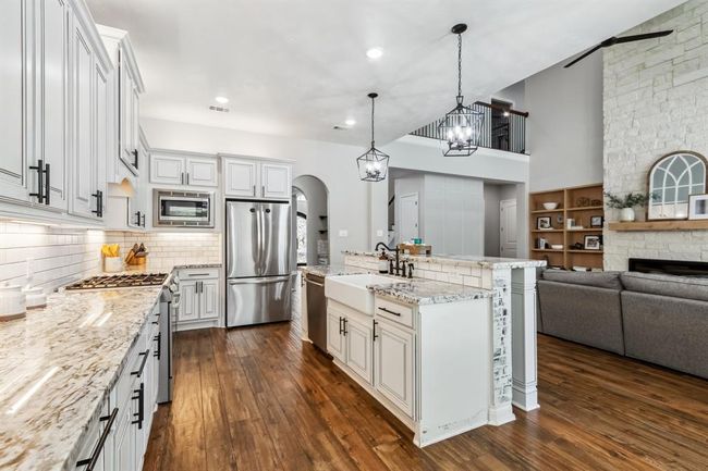 This kitchen offers both style and functionality with its granite countertops, new microwave, and abundant cabinet space. | Image 14