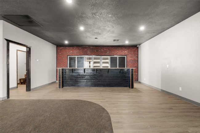 Living area featuring light wood finished floors, recessed lighting, and brick wall | Image 44