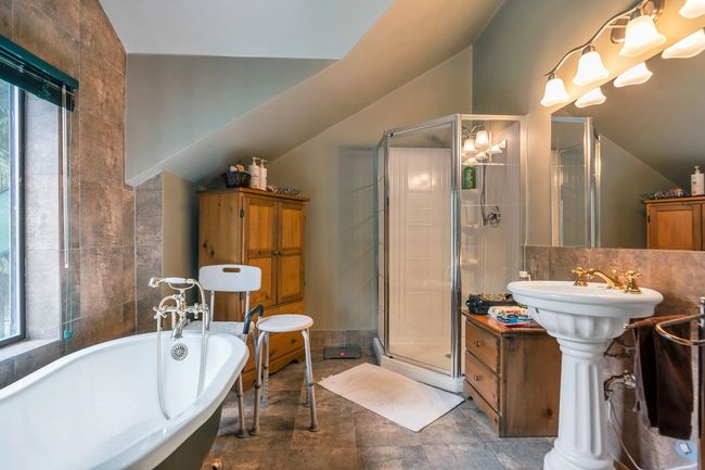 Full bath featuring tile walls, a stall shower, lofted ceiling, and a freestanding bath | Image 30