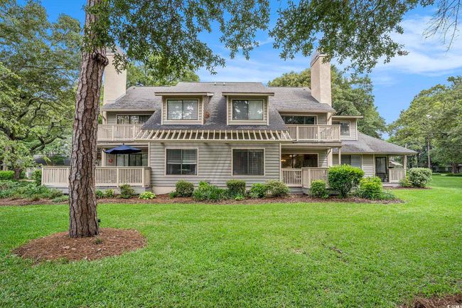 Back of house with, showing the lawn, a shingled roof, units balconies and porches. Small number of units in each pod. | Image 24
