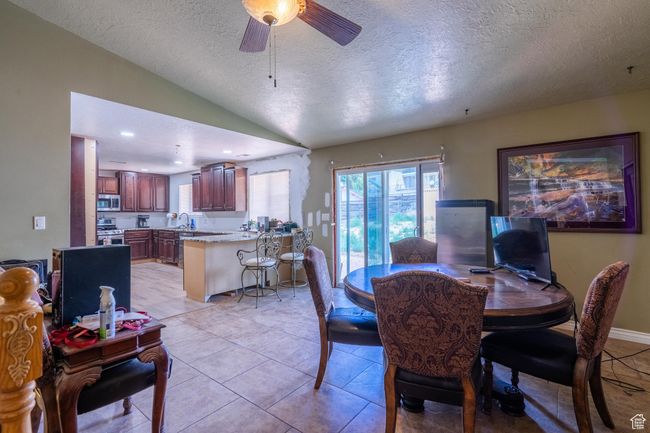 Dining area featuring a textured ceiling, lofted ceiling, and ceiling fan | Image 20