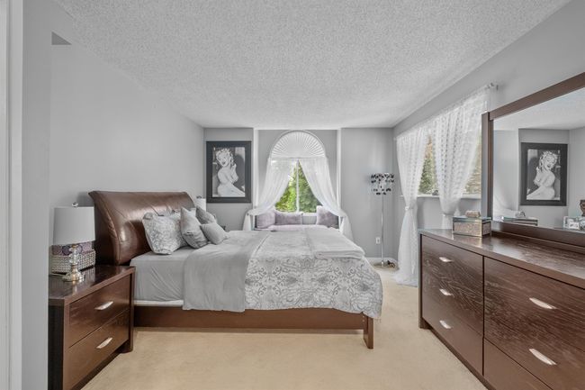 Bedroom with light colored carpet and a textured ceiling | Image 8