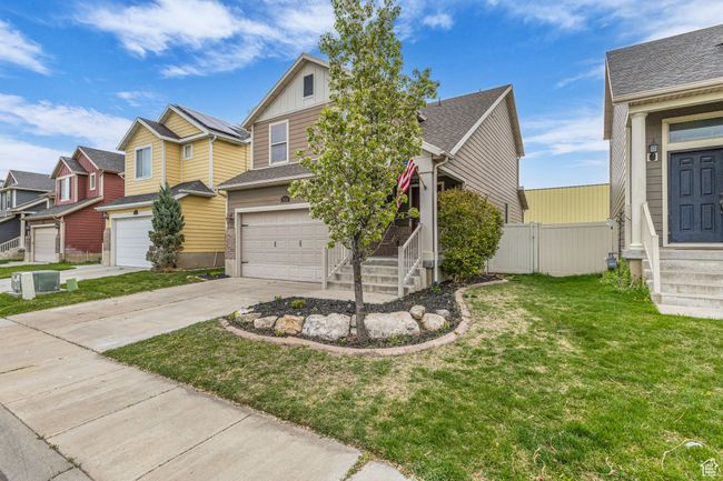 View of front of property with driveway, fence, a garage, board and batten siding, and a front yard | Image 9