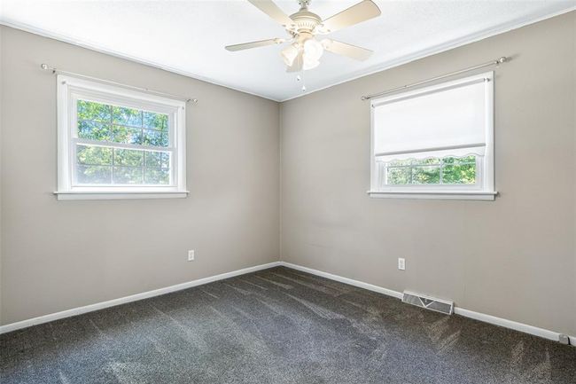 Spare room with plenty of natural light, dark colored carpet, and baseboards | Image 50