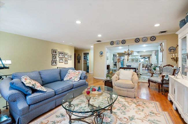 Living area featuring an inviting chandelier, recessed lighting, light wood finished floors, and crown molding | Image 5