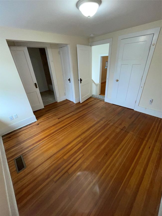 Unfurnished bedroom featuring wood finished floors and baseboards | Image 7