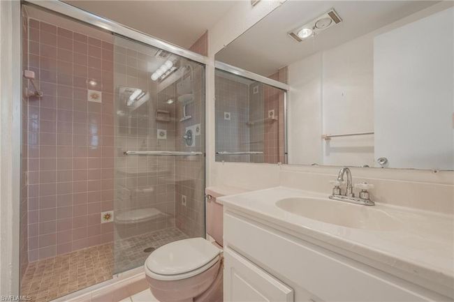 Bathroom with vanity with extensive cabinet space, toilet, and a shower with door | Image 19