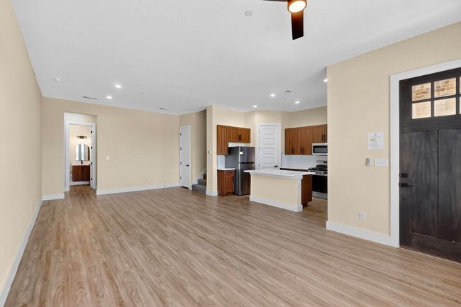 Unfurnished living room featuring light wood-style floors, stairway, recessed lighting, and ceiling fan | Image 5