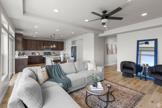 Living area featuring baseboards, light wood finished floors, recessed lighting, and ceiling fan with notable chandelier | Image 7