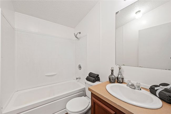 Bathroom featuring a textured ceiling, vanity, and shower / bathtub combination | Image 19