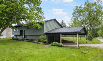 Back of house with a carport and a lawn | Image 1