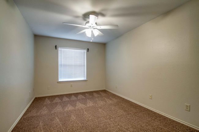 Empty room featuring dark carpet and a ceiling fan | Image 10