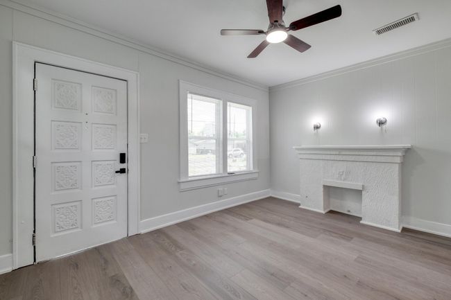 Unfurnished living room with ceiling fan, ornamental molding, and wood finished floors | Image 27