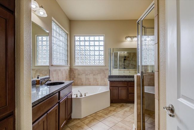 Primary Bathroom featuring tile patterned floors, vanity, a garden tub, and a walk-in shower | Image 18