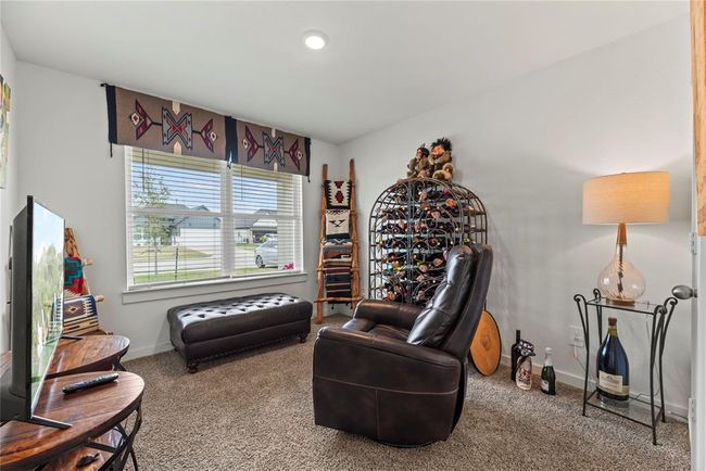 The bedroom at the front of the house is cozy and bright, featuring soft carpet underfoot for added comfort. A large window offers a peaceful view of the front yard, filling the room with natural light and creating a serene atmosphere. The light walls enhance the sense of space, making the room feel airy and inviting, while providing a neutral backdrop for personalized decor. | Image 14