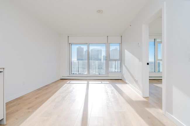 Empty room with baseboard heating, light wood-type flooring, and baseboards | Image 10