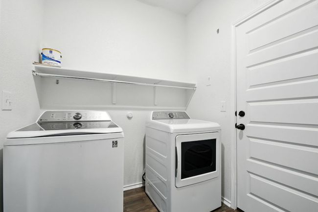 Laundry room featuring dark wood finished floors and independent washer and dryer | Image 15