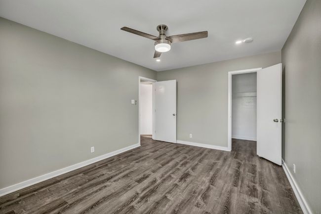 Unfurnished bedroom with dark wood-type flooring, baseboards, a closet, a spacious closet, and recessed lighting | Image 16
