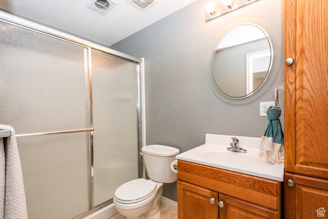 Full bathroom with a shower stall, toilet, vanity, and tile patterned floors | Image 29