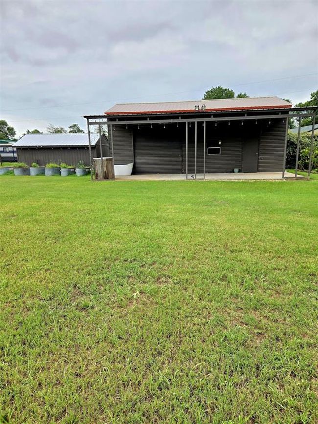 Barn with view of patio, garage door and storage shed. | Image 37