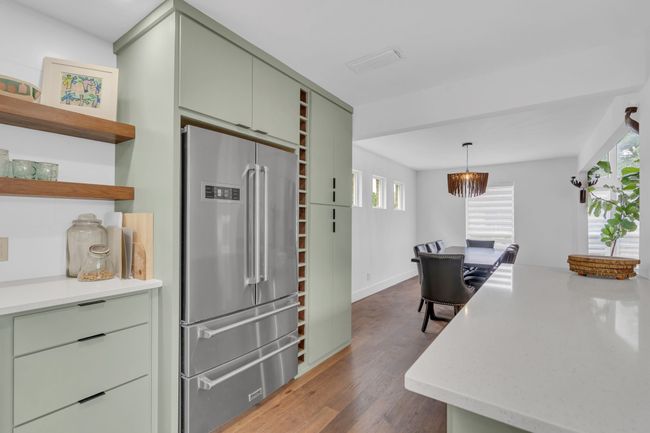 Kitchen with visible vents, open shelves, green cabinetry, high end refrigerator, and dark wood finished floors | Image 19
