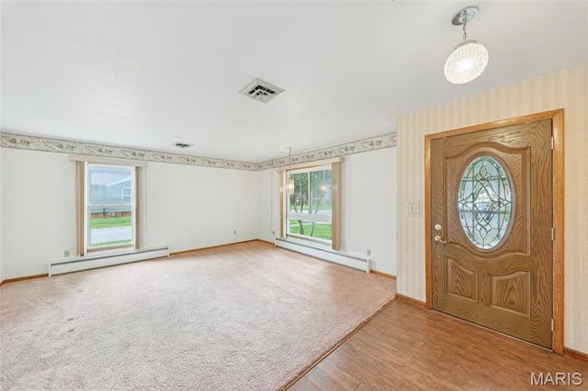 Entryway featuring a baseboard heating unit, baseboard heating, wood finished floors, and wallpapered walls | Image 10
