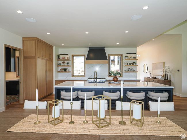 Kitchen with open shelves, dark wood-style flooring, a center island with sink, premium range hood, and recessed lighting | Image 39