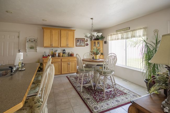 Dining area featuring light tile patterned floors and an inviting chandelier | Image 7